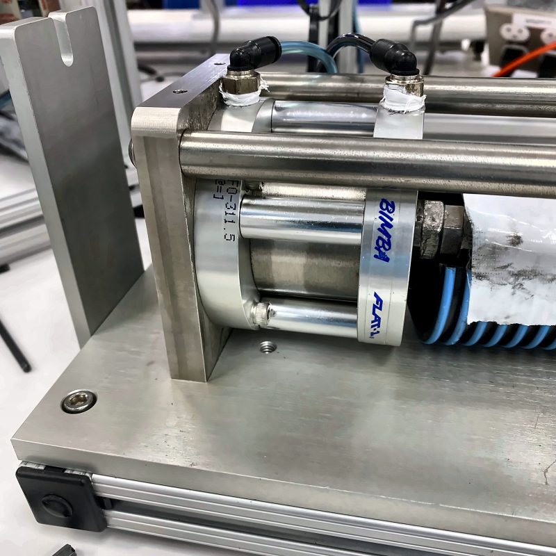 Air cylinder held in a machined aluminum bracket with stainless guide rods